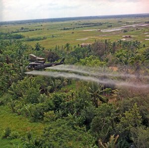 Een UH-1D helikopter van de 336th Aviation Company sproeit een ontbladeringsmiddel over een dicht junglegebied in de Mekong Delta, 26 juli 1969 door American Photographer